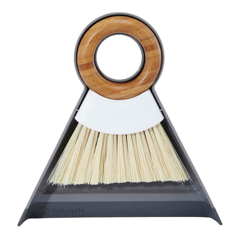 Cleaning brush with bamboo handle and grey dustpan on a white background