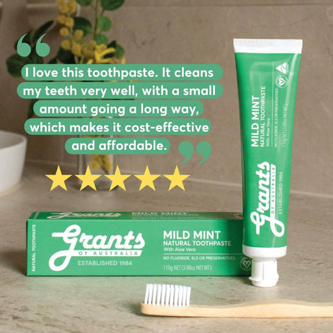 Grants toothpaste tube, box, and bamboo toothbrush arranged on a counter with a customer testimonial overlay.