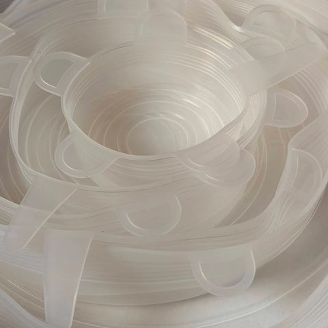 A close-up of a stack of translucent white silicone lids.