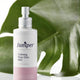 Jumiper Calming Rose Otto Mist bottle with green leaves in the background