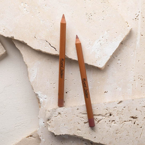 Two mineral goddess lip pencils on a stone background. 