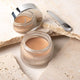Mineral Goddess luxury cream foundation jar with a scoop on a stone background