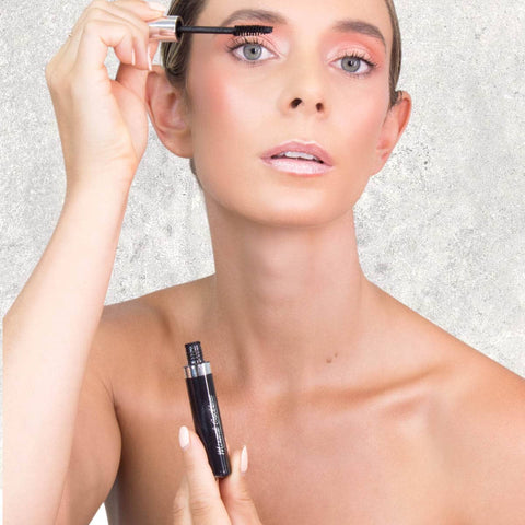 Model applying mineral goddess mascara to her lashes.