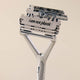 Metallic razor with 'i am not plastic' text on a beige background