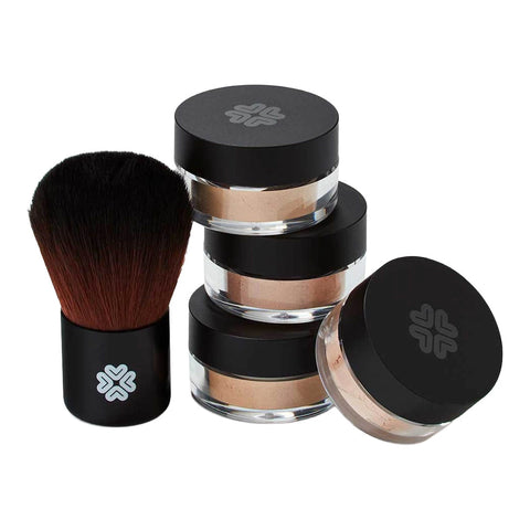 Mineral foundations & finishing powder stacked next to a kabuki brush.