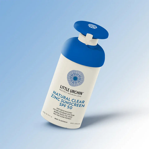 Little Urchin Natural Clear Zinc Sunscreen SPF 50 300g pump bottle tilted at an angle with a soft shadow on a pale blue gradient background