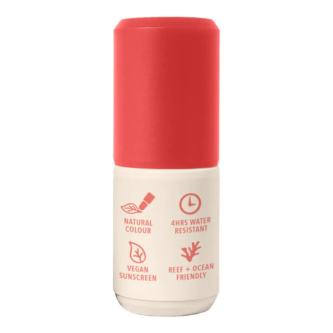 A cylindrical sunscreen bottle with a vibrant coral-red cap and a cream-colored lower body, featuring red text and icons highlighting product features.