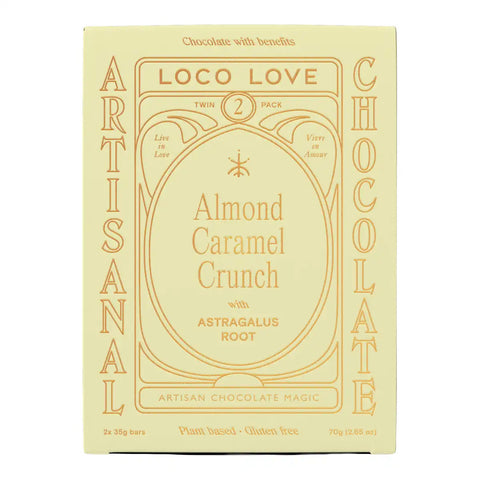 A pale yellow rectangular box of Loco Love Almond Caramel Crunch chocolate, featuring elegant tan typography and decorative borders, with 'Artisanal' printed vertically on the sides.