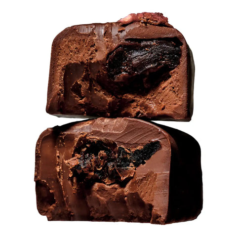 Two halves of a chocolate confection stacked vertically, showing a rich dark chocolate center.