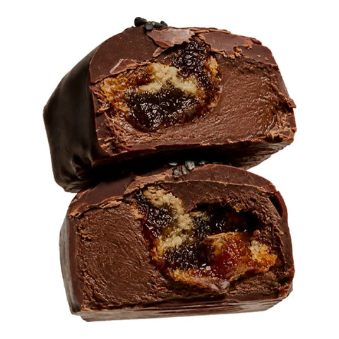 Two halves of a chocolate-covered confection showing a dark caramel and cookie-like filling, photographed on a plain white background.