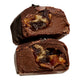 Two halves of a chocolate-covered confection showing a dark caramel and cookie-like filling, photographed on a plain white background.