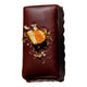 Chocolate covered truffle with ginger pieces and orange peel decoration. 