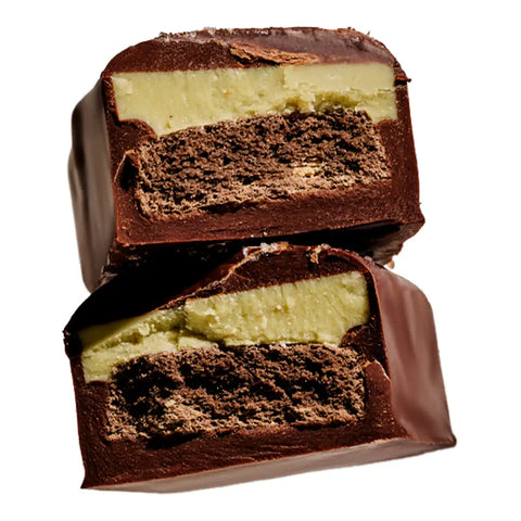 Two stacked chocolate-covered treats with a pale cream filling and a dark brown crumb center, shown on a plain white background.