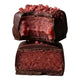 Strawberry vanilla burst chocolate halved and stacked - reddish pink center coated in dark vegan chocolate with freeze dried strawberry sprinkles on top.