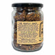 A clear glass jar of Mindful Foods Maple Cinnamon Nuts with a black lid and a tan paper label, shown on a plain white background.