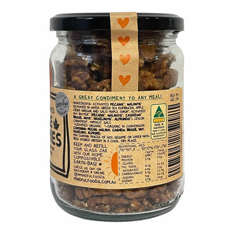 A glass jar of Mindful Foods organic activated pecans on a white background, showing the back of the kraft paper label with ingredients, nutrition facts, and a barcode.