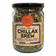 A glass jar of Mindful Foods Byron Bay Chillax Brew organic herbal tea with a black lid and a beige paper label, shown on a white background.