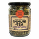 A 100g glass jar of Mindful Foods Byron Bay Immuni Tea, featuring a black lid and a brown kraft paper label with black text, filled with dried green herbal tea blend.