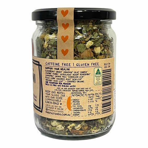 A clear glass jar of herbal tea with a black lid and a tan paper label, shown on a white background. The label reads 'CAFFEINE FREE | GLUTEN FREE' and features a vertical strip of orange hearts on the lid.