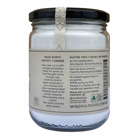 Back view of a glass jar of Mindful Foods Creatine Monohydrate with a black lid and a white label containing product details and a barcode.