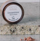Jar of Eco Minerals Dreamtime Mineral Blush on a stone surface.