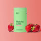 Green container labeled 'Matcha Latte Strawberry Blend' with strawberries on a pink background