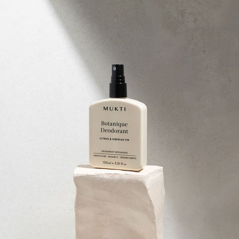 MUKTI Botanique Deodorant - Citrus & Siberian Fir 100ml spray bottle on a stone block. 