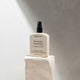 MUKTI Botanique Deodorant - Citrus & Siberian Fir 100ml spray bottle on a stone block. 