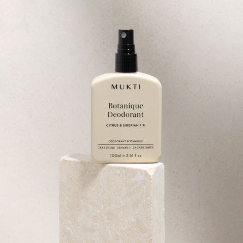 MUKTI Botanique Deodorant - Citrus & Siberian Fir 100ml spray bottle on a stone block.