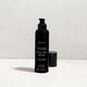 Black skincare bottle labelled 'Solar Veil SPF30' by Mukti on a light grey background.