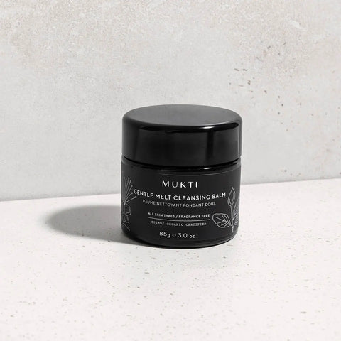 Gentle Melt Cleansing Balm on a textured surface.