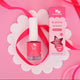 Nail Polish and packaging styled on a pink & white background with a pink ribbon.