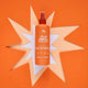 Orange hair detangler bottle with star-shaped cutout on an orange background.