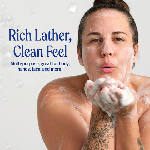 Woman with foamy hands and face, promoting a product with text 'Rich Lather, Clean Feel' on a light background.
