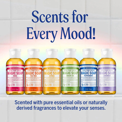 Six Dr. Bronner's Magic Soap bottles in different scents (Rose, Tea Tree, Citrus, Green Tea, Peppermint, Lavender) lined up on a white shelf against a light tiled background.