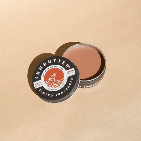 Sunbutter skincare tinted sunscreen tin on a beige background