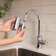 Person holding the water filter next to the tap in the process of installing it.