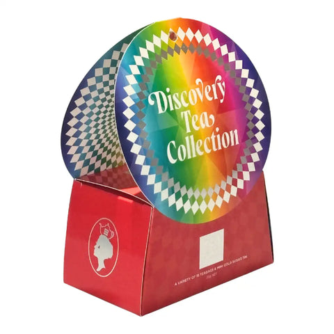 A red cardboard display box for a tea collection, featuring two circular hanger signs. The front sign has a rainbow gradient with white text reading 'Discovery Tea Collection' and a white diamond border.