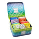 An open teal and green geometric metal tea tin filled with assorted tea bags in colorful packaging, with the brand name TEA TONIC visible on the lid and front of the tin.
