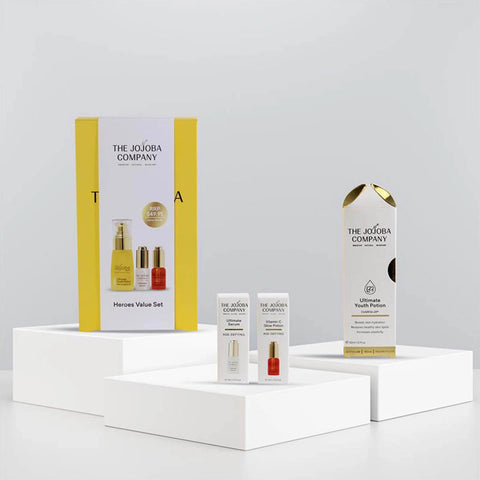 The Jojoba Company Heroes Value Set with packaging of each product staged on white blocks with a gradient white-grey background.
