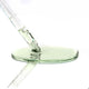 Glass dropper with a green clear liquid on a white background