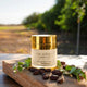 Jojoba oil container with jojoba seeds on a stone surface with a natural background