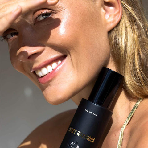 Tanned woman holding mist.