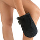 Black eco-friendly tanning mitt on a person's knee with a plain background.