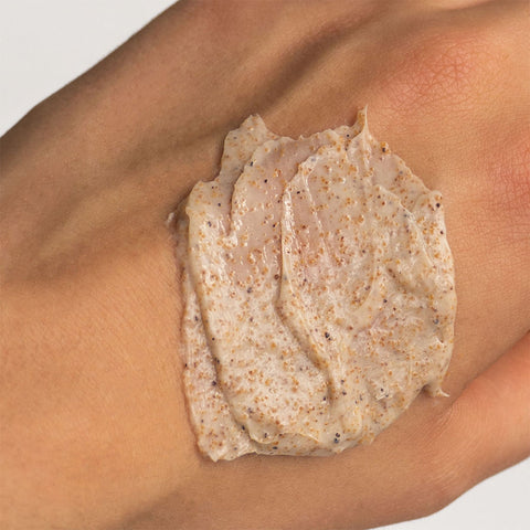 Three Warrors' Tasmanian Sand Scrub, an organic, vegan and cruelty-free body exfoliator formulated with aloe vera, coconut oil and natural sand sourced locally from Tasmanian beaches, applied onto a hand showing a closeup of the product's gritty texture.