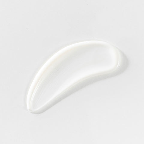 White cream smear on a light gray background.